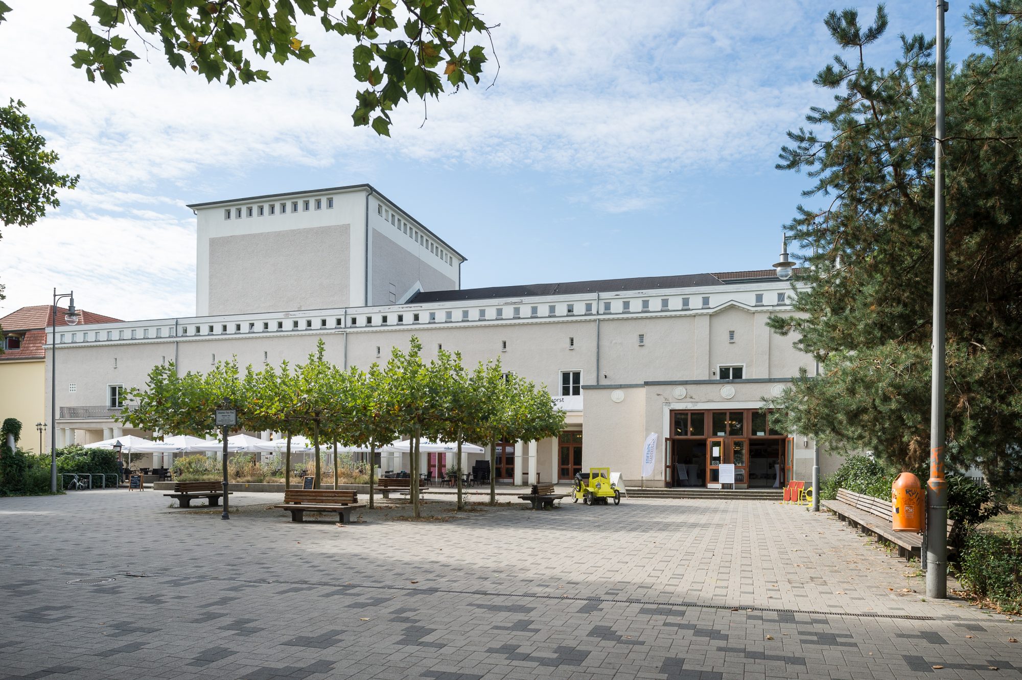 Zu sehen ist das ehemalige Theater Karlshorst, fotografiert vom Johannes-Fest-Platz. Der Himmel ist blau.